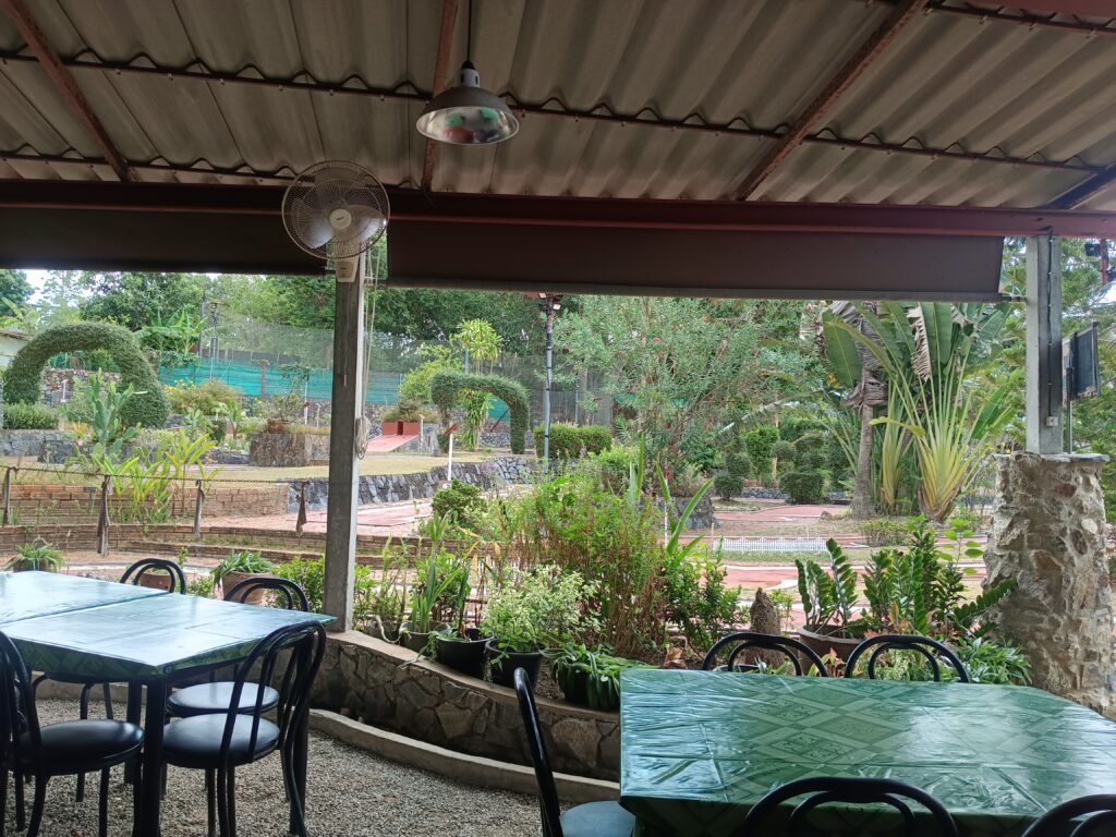 chairs and tables in cool shaded are at golf course
